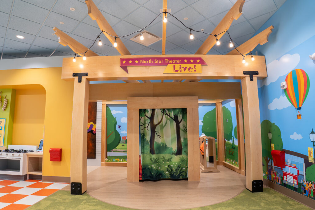A children's play theater with a forest backdrop.