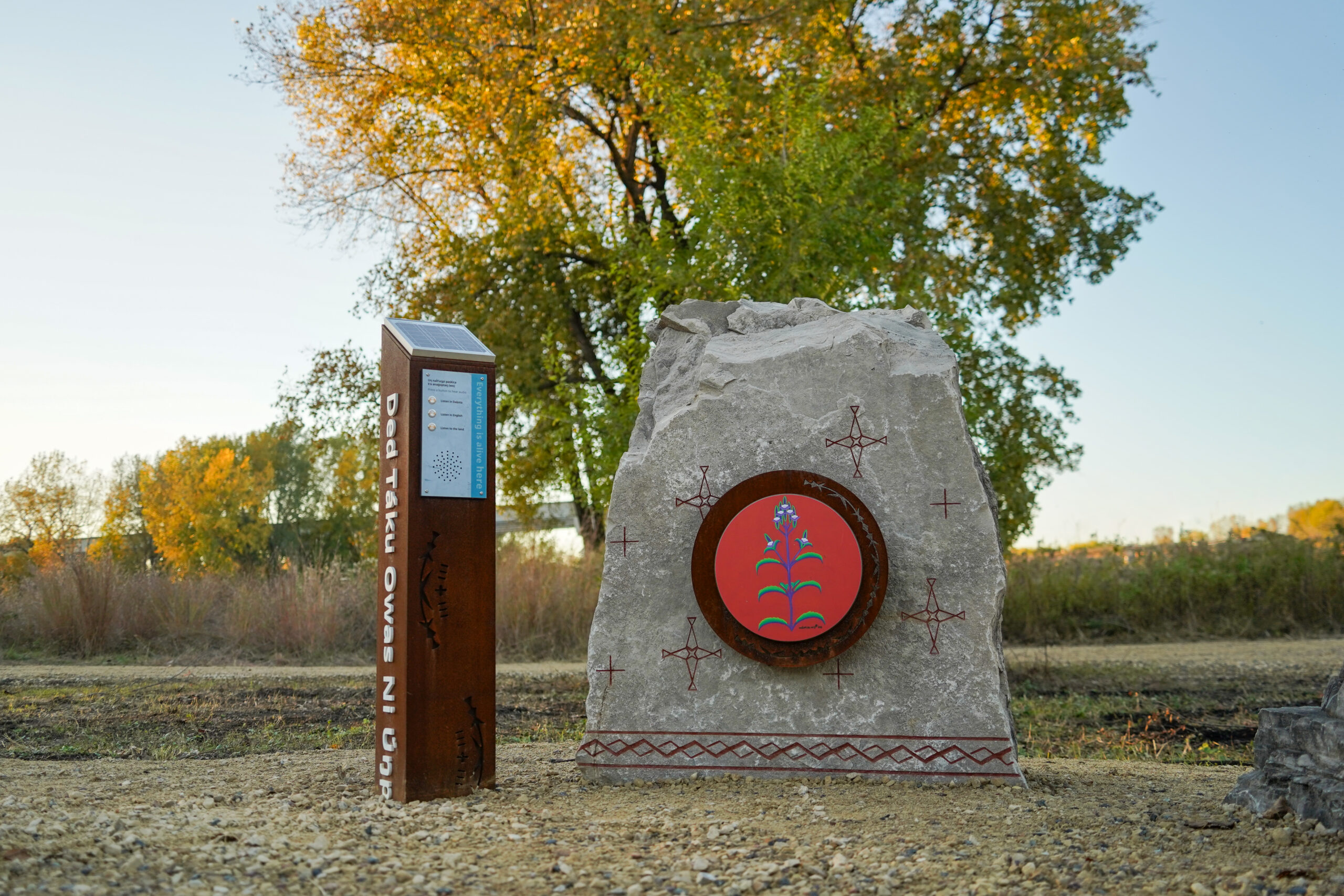 A rock with painting and a rust colored post